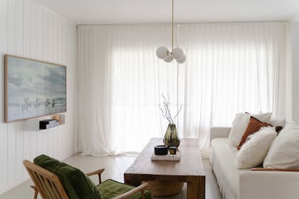 Los almohadones de cuero de gamuza y suela suman color y personalidad a un sillón color crudo