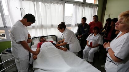 Los alumnos Iván Zamorano y Marina Llampa, durante un práctica en un aula que simula ser un hospital