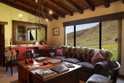 Los ambientes comunes de la estancia invitan a relajarse y sus ventanales conectan con el entorno montañoso.