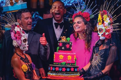 Los anfitriones Antonio Banderas y Sandra García-Sanjuán junto al invitado de honor, Will Smith, con la torta decorada en tributo al Día de los Muertos, una de las celebraciones populares más importantes de México.