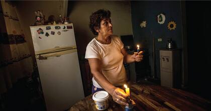 Los apagones afectan a todos, como Nadia Rodríguez, que tiene que alumbrarse con velas durante las horas de racionamiento