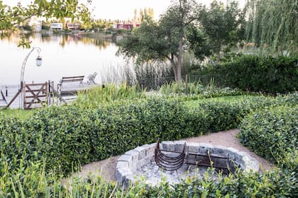 Los arbustos alrededor del fogón delimitan el sitio y terminan de darle entidad propia a ese espacio del jardín. Además, son aliados para proteger al fuego del viento.