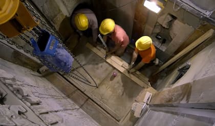 Los arqueólogos de la Universidad de Atenas remueven la más que milenaria lápida de mármol que cubre la tumba de Jesús en el Santo Sepulcro (captura de TV)