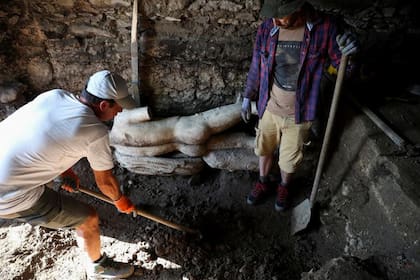 Los arqueólogos observan una estatua de mármol descubierta en la antigua ciudad de  Heraclea Sinitica