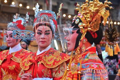 Los artistas de la ópera tradicional china de Sai Yong Hong con protectores faciales