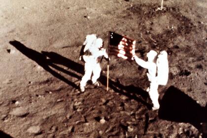 Los astronautas del Apolo 11 Neil Armstrong y Edwin "Buzz" Aldrin, los primeros hombres que aterrizaron en la luna, plantan la bandera de los EE. UU. en la superficie lunar, el 20 de julio de 1969. Una cámara de 16 mm hizo la foto desde el módulo lunar, disparando a un cuadro por segundo