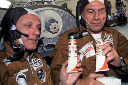 Los astronautas Stafford y Slayton sostienen los tubos de "vodka" a bordo del Soyuz
