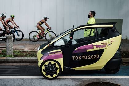 Los atletas pasan junto a un motor de tres ruedas oficial durante la competencia individual femenina de triatlón en los Juegos Olímpicos de Tokio 2020 en el Parque Marino de Odaiba en Tokio el 27 de julio de 2021