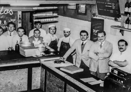 Los Banchero junto a los empleados de la pizzería.