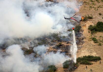 Los bomberos combaten el fuego con helicópteros y desde el suelo 