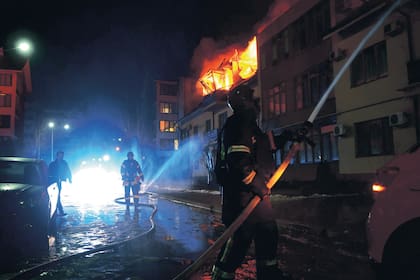 Los bomberos combaten las llamas de una vivienda que fue impactada por un dron ruso en Zaporiyia, Ucrania (Archivo)