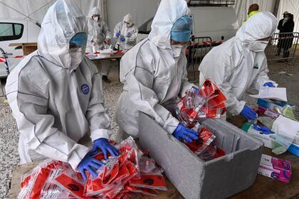 Los bomberos con trajes protectores manejan las pruebas realizadas en un centro de pruebas de Covid-19 el 14 de octubre de 2020 en Montpellier