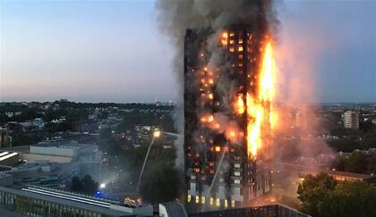 Los bomberos intentaban ayer sofocar las llamas del incendio en el edificio de Londres