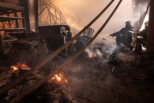 Los bomberos luchan contra un incendio después de que los ataques rusos golpearan un almacén en los suburbios de Kiev el 24 de marzo de 2022.