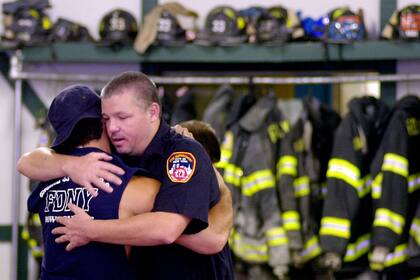 Los bomberos Sal Princiotta (izquierda) y Donald Casey se abrazan en la estación de bomberos Engine 33 en Nueva York, el sábado 15 de septiembre de 2001. Cientos de bomberos estaban desaparecidos después del ataque terrorista al World Trade Center.