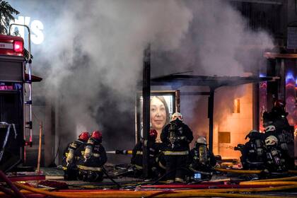 Los bomberos trabajan en el incendio de la perfumería