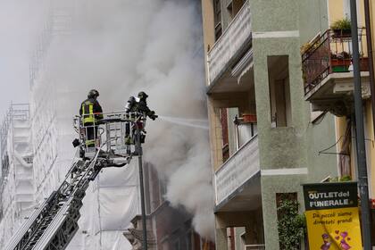 Los bomberos trabajan para extinguir un incendio en un edificio tras la explosión de una furgoneta en el centro de Milán, en el norte de Italia, el jueves 11 de mayo de 2023.