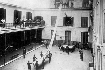 Los bomberos voluntarios tuvieron su origen en 1884; en esta imagen se observa una práctica de salvamento en Buenos Aires seis años después, con un niño deslizándose sobre una tela desde un piso superior