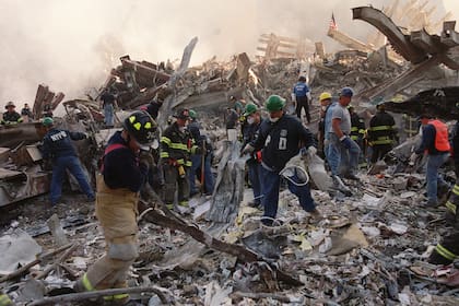 Los bomberos y el personal de emergencia retiran los escombros del lugar del colapso de las torres del World Trade Center en Nueva York, el jueves 13 de septiembre de 2001