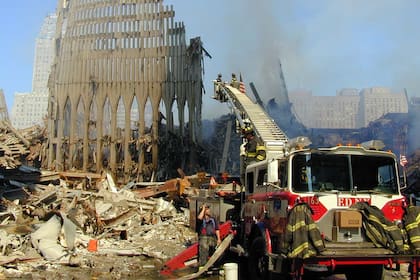 Los bomberos y los rescatistas urbanos de Nueva York revisan los escombros del World Trade Center en Nueva York en busca de sobrevivientes el martes 18 de septiembre de 2001