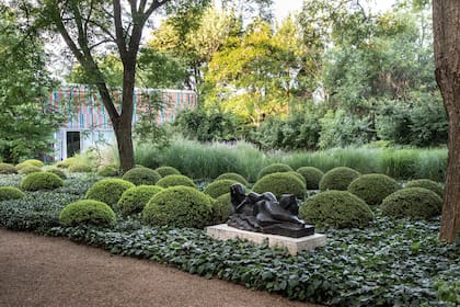 Los buxus son olas que acompañan la escultura y le dan un fondo verde y bajo que la resalta.