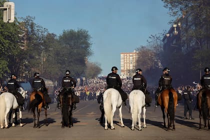 Los caballos trabajan junto al personal policial en la prevención del delito, en servicios o eventos de concentración masiva de personas. En la foto agentes de la policía nacional española patrullan con sus caballos mientras los seguidores del Real Madrid esperan la llegada de su equipo fuera del estadio Santiago Bernabeu en Madrid.