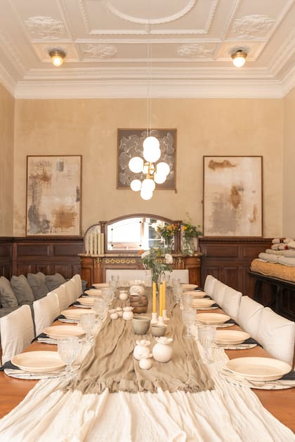 Los caminos de lino y la vajilla en cerámica contrastan con la formalidad del comedor tradicional.