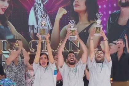Los campeones Nico Occhiato y Flor Jazmín Peña alzando la copa junto a su coach