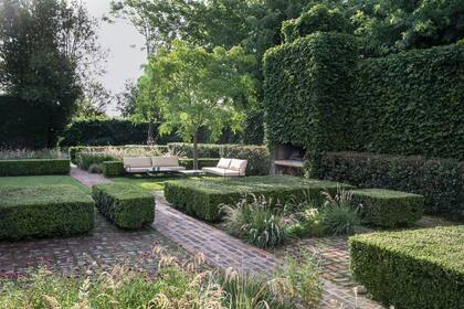 Los cercos, muros y volúmenes de buxus podados aportan estructura, organizan espacialmente el jardín y producen efectos interesantes de luz y sombra. En el sector de la parrilla se creó un lugar de estar a la sombra.