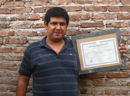 Miguel muestra dichoso su diploma de bachiller