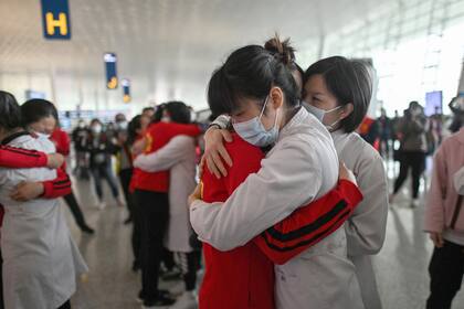 Enfermeras se abrazan luego de haber trabajado en conjunto para atender a los enfermos