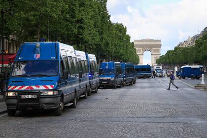 Los coches de la policía francesa se alinean en la avenida de los Campos Elíseos en París, donde se prohibieron tres manifestaciones