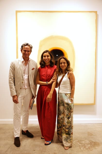 Los coleccionistas peruanos Alberto “Tito” Rebaza y Ginette Lumbroso con Irene Gelfman, curadora global de Pinta, y obra de Tony Vázquez-Figueroa