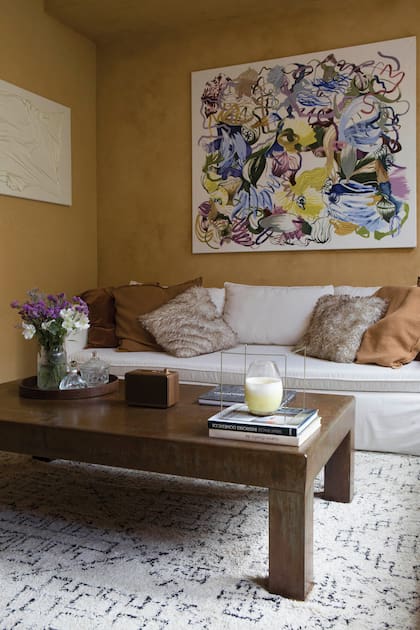 Los colores de Andrea Santarelli dan la bienvenida “al corazón de la casa”. En la pared lateral, obra de Verónica (Il Vero Art). Sobre la mesa de madera (Las Marías), un libro escrito por el dueño sobre su recorrido y pasión por el arte.