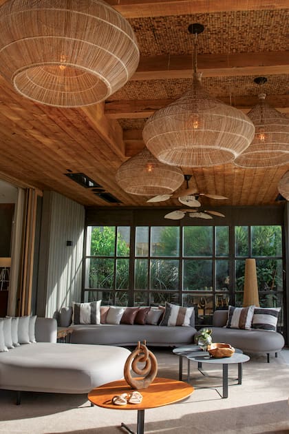 Los comodísimos sillones de la galería invitan a la charla relajada. “Me gusta sumar materiales que te relajen, como la esterilla, la rafia o el yute. Si bien son más rústicos, en una casa sólida quedan bien”, afirma Vero