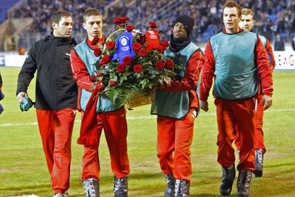 El equipo rival carga flores en memoria de la mujer de su colega