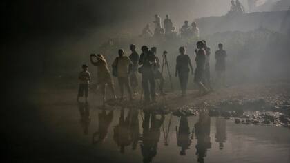 Espectadores envueltos en humo por las bengalas mientras miran a los competidores