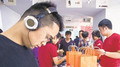 Los consumidores prueban distintos teléfonos de Xiaomi en el primer día del lanzamiento del esperado modelo Mi Note, que salió a la venta en mayo de 2015.
