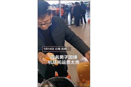 Los cuatro hombres se comieron casi dos cajones de naranjas en menos de 30 minutos para no pagar por exceso de equipaje           Foto: captura de pantalla de Feidian Video en Sina Weibo