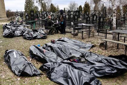 Los cuerpos están alineados para su identificación por parte del personal forense y los agentes de policía en el cementerio de Bucha, al norte de Kiev.