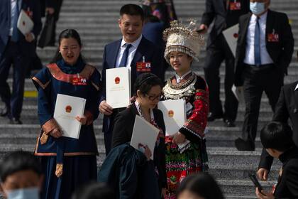 Los delegados posan para una foto con las carpetas de sus papeletas de votación después de una sesión de la Asamblea Popular Nacional de China (APN) en el Gran Salón del Pueblo en Pekín, el viernes 10 de marzo de 2023.