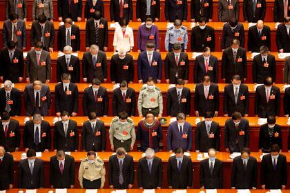 Los delegados se inclinan para expresar sus condolencias a las víctimas del coronavirus.