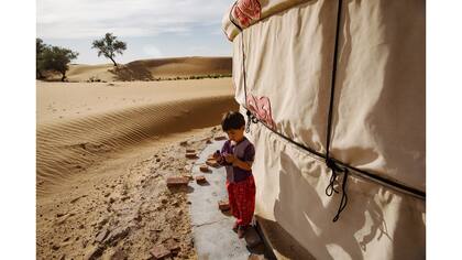Liu Jiali, de 3 años, afuera de su casa en el desierto de Tengger