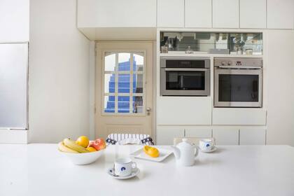 Los detalles en espejos son otro guiño que se repite en todos los ambientes. Detrás de la puerta la escalera azul que conduce a la terraza.