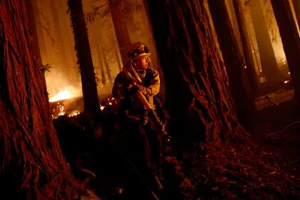 El bombero Anthony Quiróz busca proteger una casa de las llamas en Boulder Creek