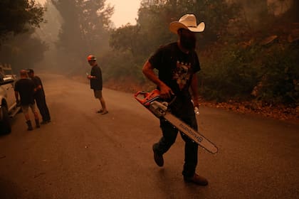 El voluntario Isaiah Klinger ayuda a combatir el fuego con un grupo de amigos en Santa Cruz, California