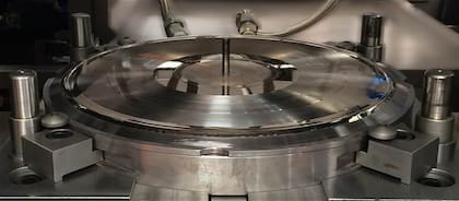 Los discos estampadores de níquel (uno para el lado a y otro para el lado b del disco) se ubican en la máquina prensadora.