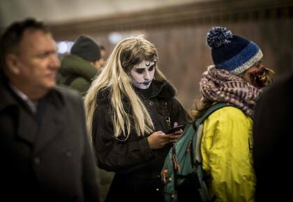 Una mujer disfrazada espera en el metro de Moscú 