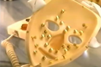 Los electrodos dorados lucían amenazantes en el lado interno de la máscara facial reuvenecedora eléctrica