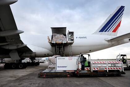 Los empleados cargan un contenedor farmacéutico en un avión de carga de Air France en el aeropuerto de Roissy, al norte de París, el 25 de noviembre de 2020, mientras la compañía se prepara para el transporte y almacenamiento de las vacunas contra el coronavirus